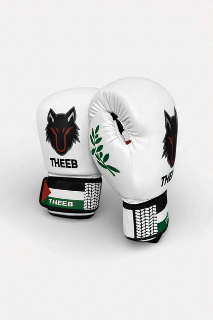 THEEB Falastini boxing gloves in white PU leather with black wolf logo and Palestinian flag detail on wrist strap.