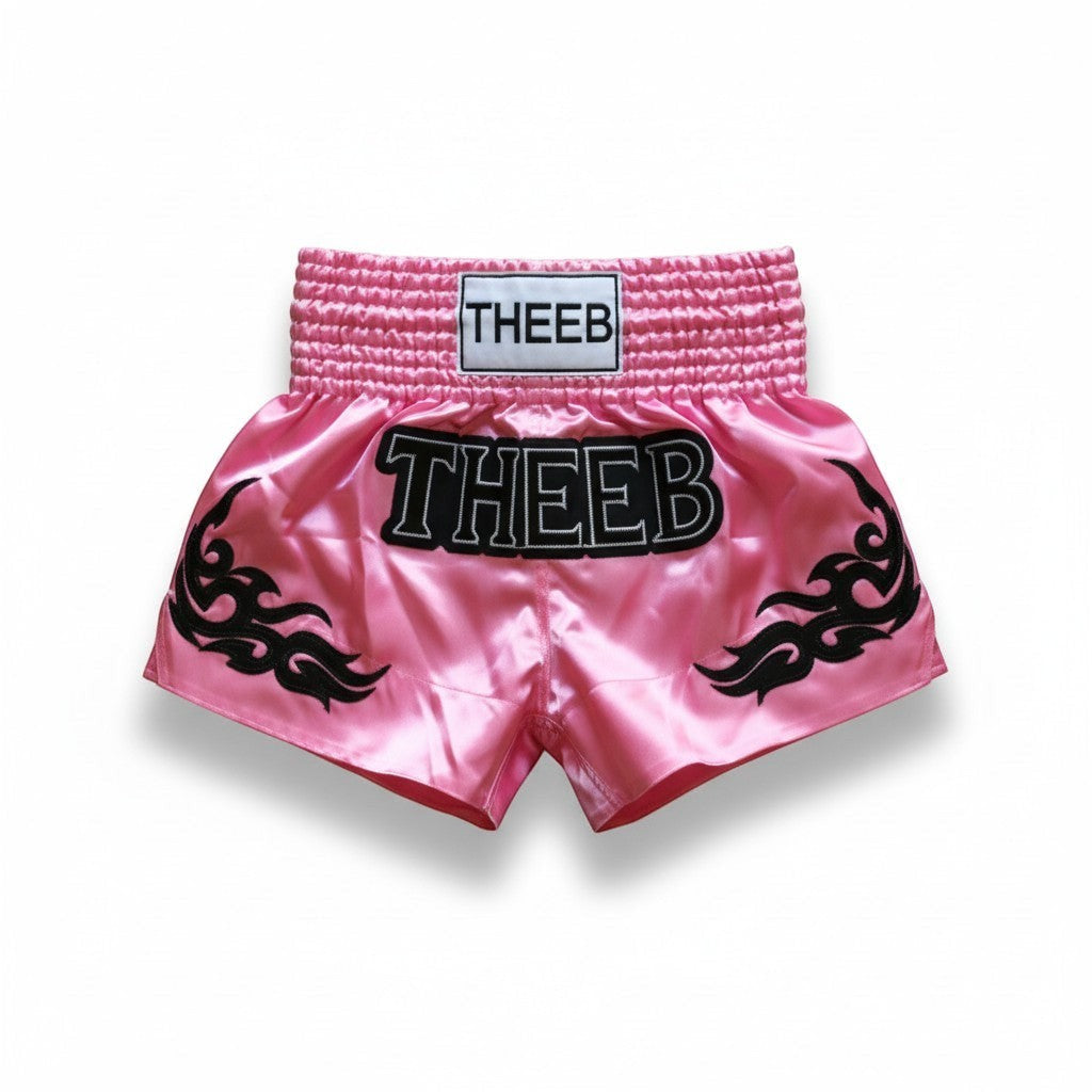 My Store THEEB Glorify pink satin Muay Thai shorts with black flame details and elastic waistband.