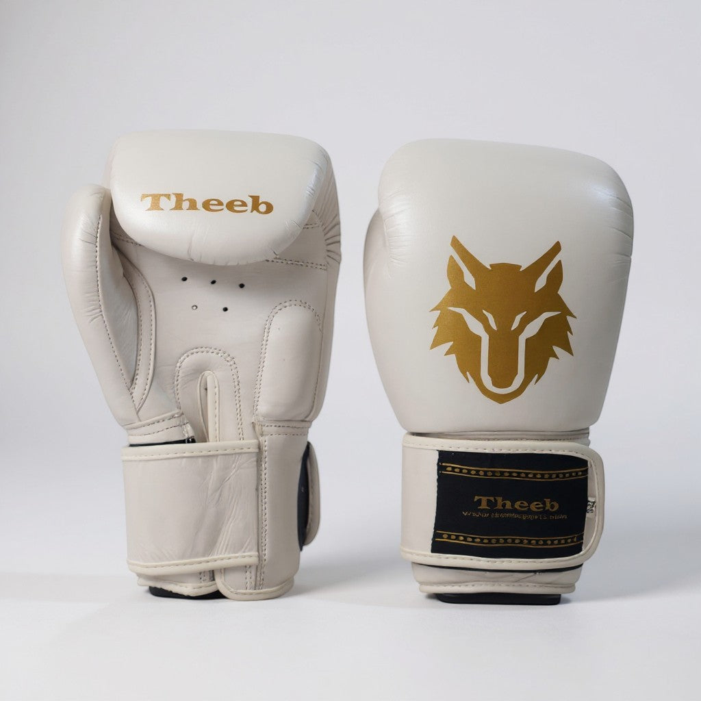 My Store Theeb Golden Age kids Muay Thai gloves in off-white genuine leather with gold wolf logo and secure wrist strap.