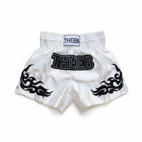 My Store white satin Muay Thai shorts with black tribal flame accents and THEEB logo, designed for performance and comfort.